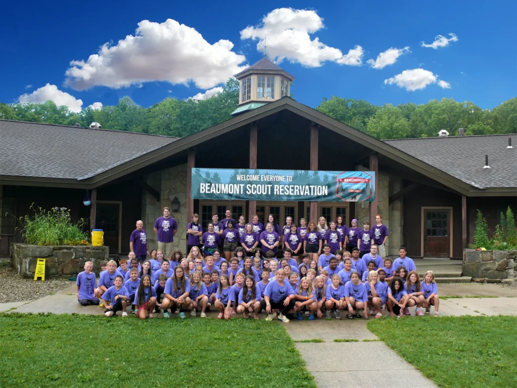 Children from the 2021 Children's Camp all pose together, underneath a Camp Beaumont Banner.